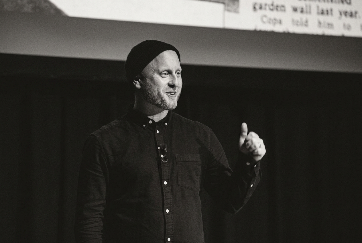 Blake Ezra speaking on stage during his one-man show, Human